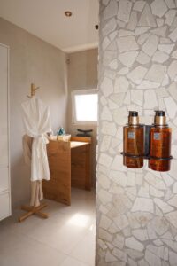 B&B badkamer - Luxe badjas en natuurstenen muur